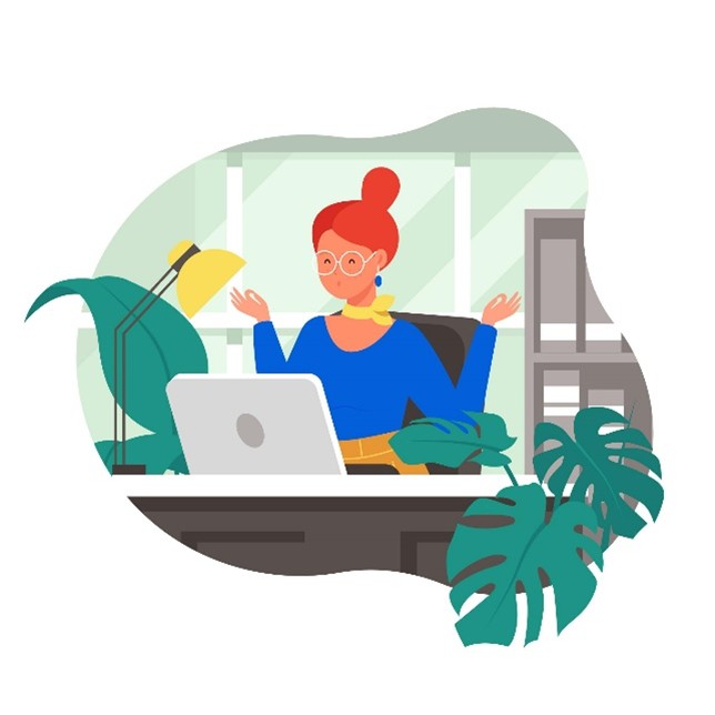 Frau mit Laptop sitzt im Homeoffice zwischen Zimmerpflanzen und Schreibtischlampe.